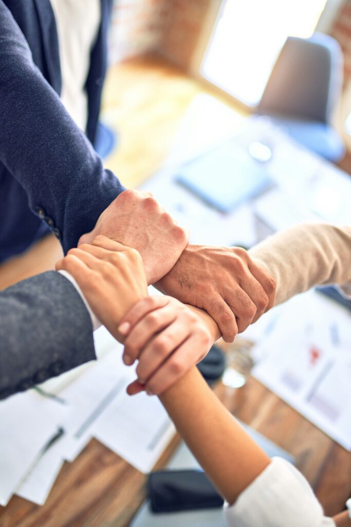 Erfolg Menschen reichen sich die Hand: Denn Erfolg ist eine Teamleistung!