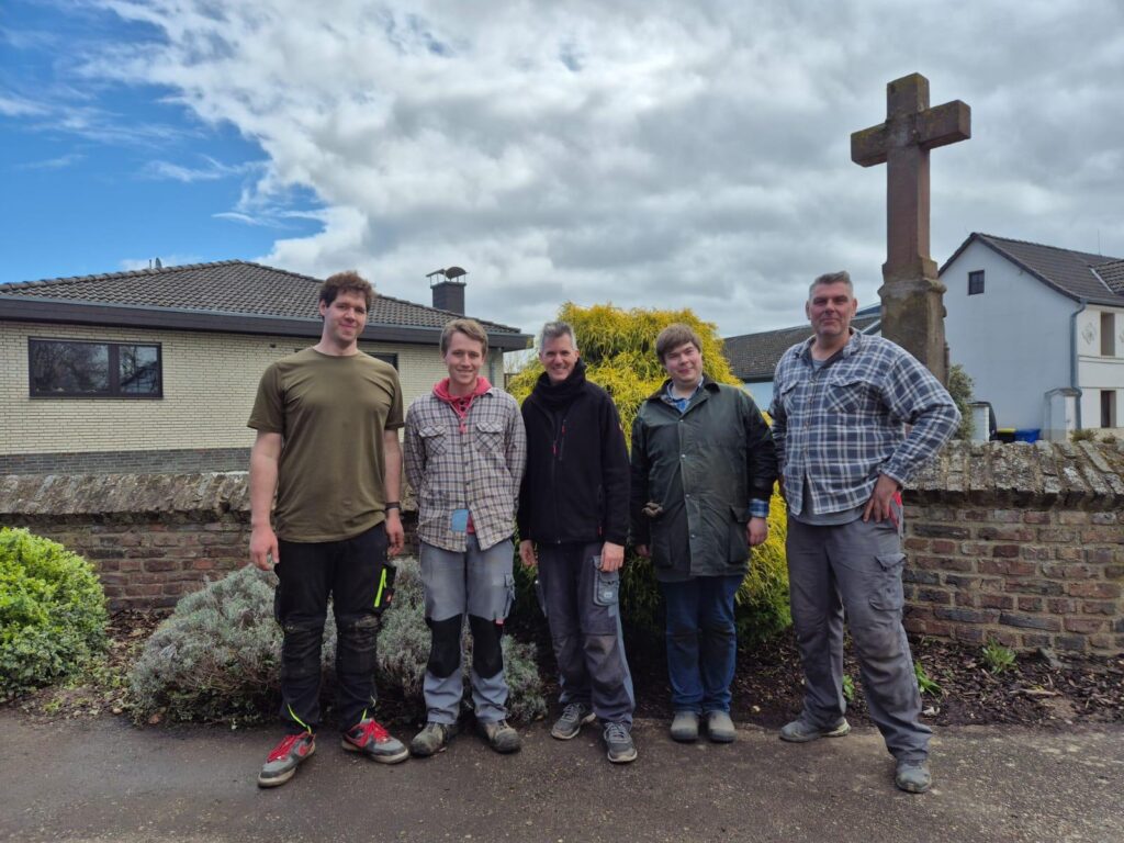 So sehen Sieger aus Ein Bild von unseren Tatkräftigen Helfern vor einem frisch geharkten Blumenbeet.